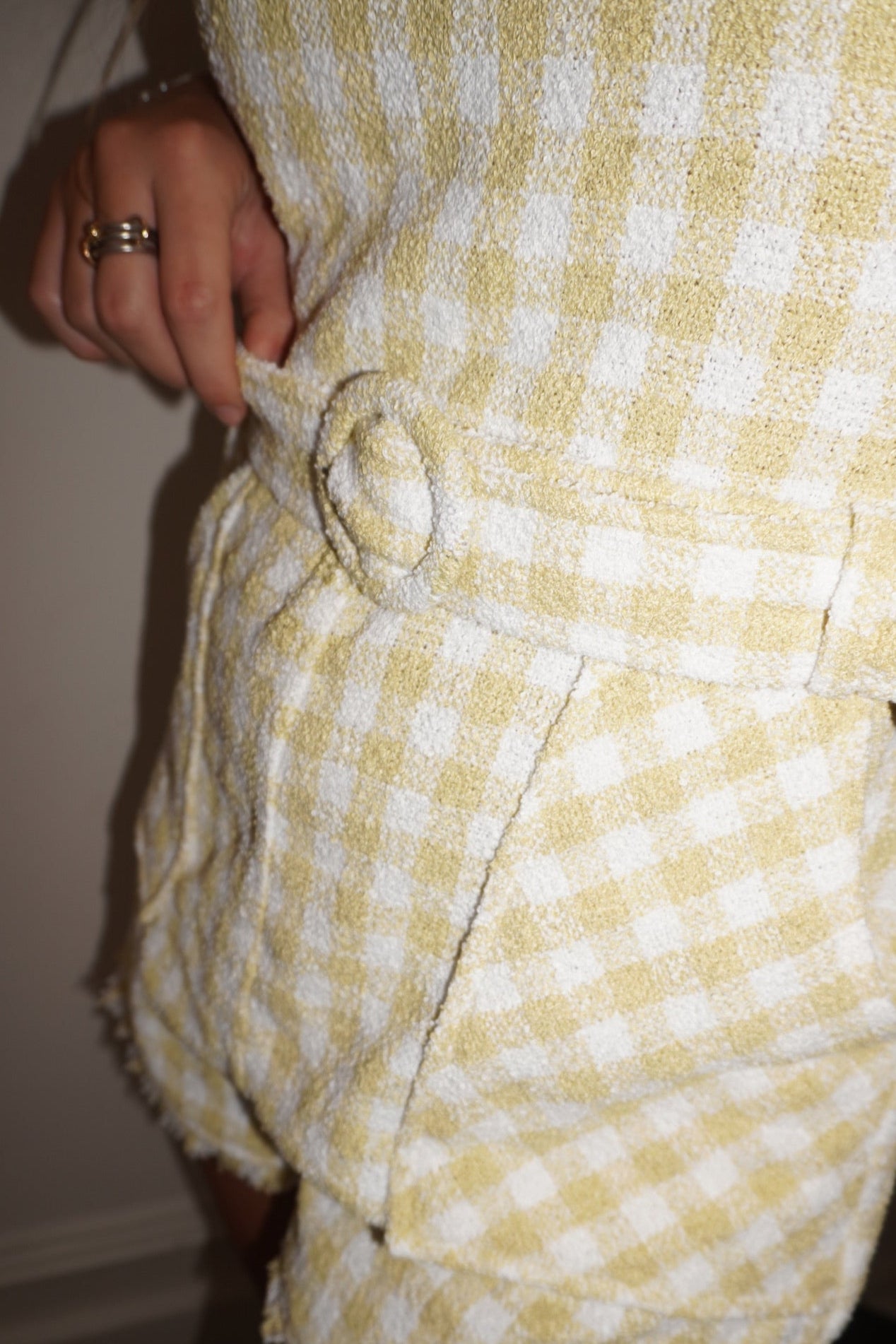 Yellow and white checkered pants with a belt being worn.