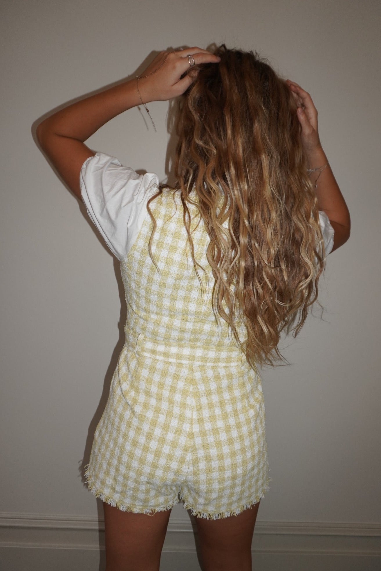 Person wearing a yellow checkered outfit with a plain background