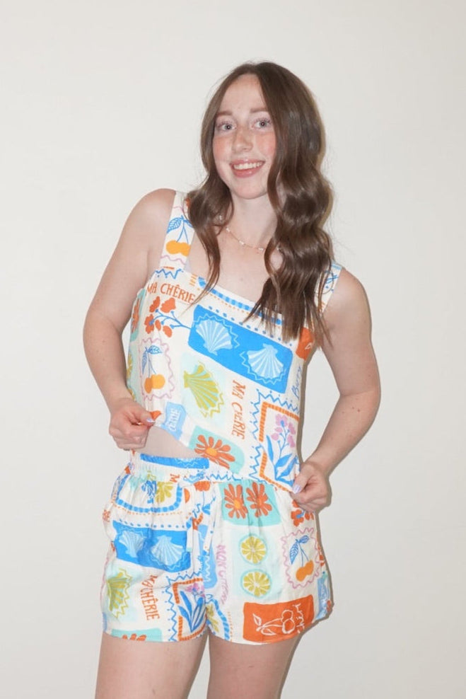 Person wearing a colorful sleeveless dress with patterns and text.
