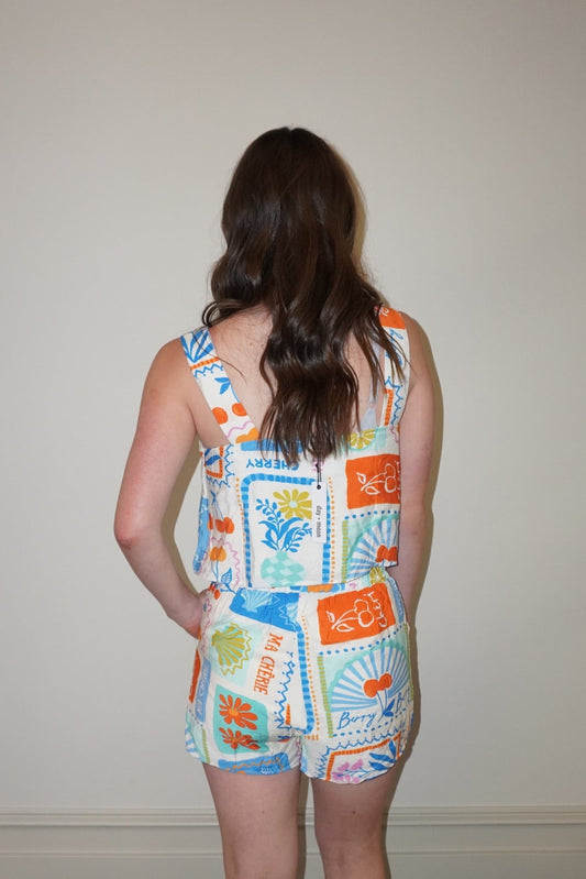 Person wearing a colorful patterned set  standing against a plain wall.