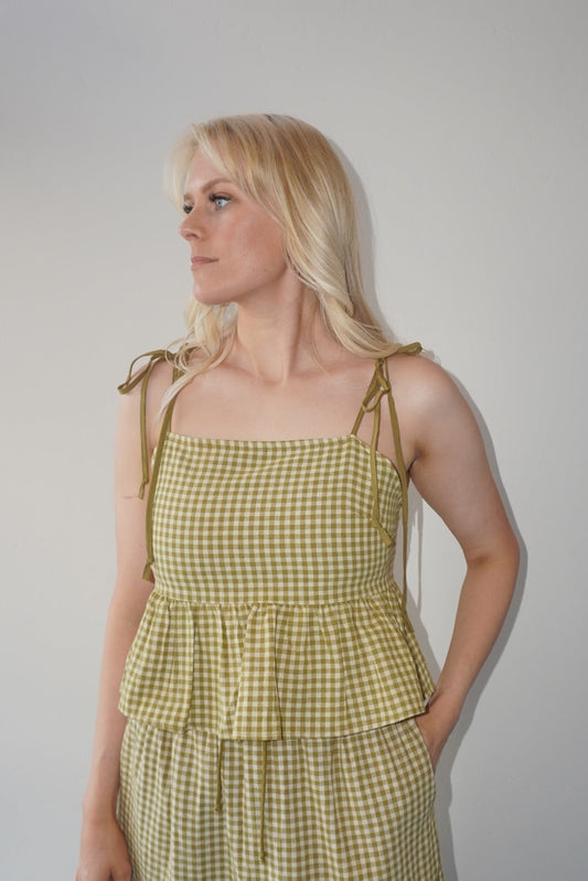Woman wearing a green checkered set against a plain background