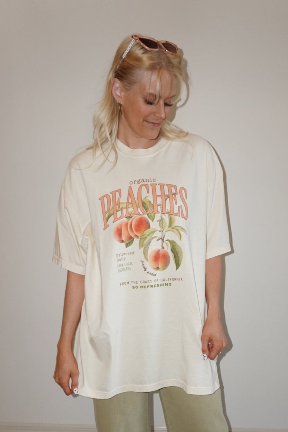 Person wearing a graphic t-shirt and light-colored pants on a checkered floor.