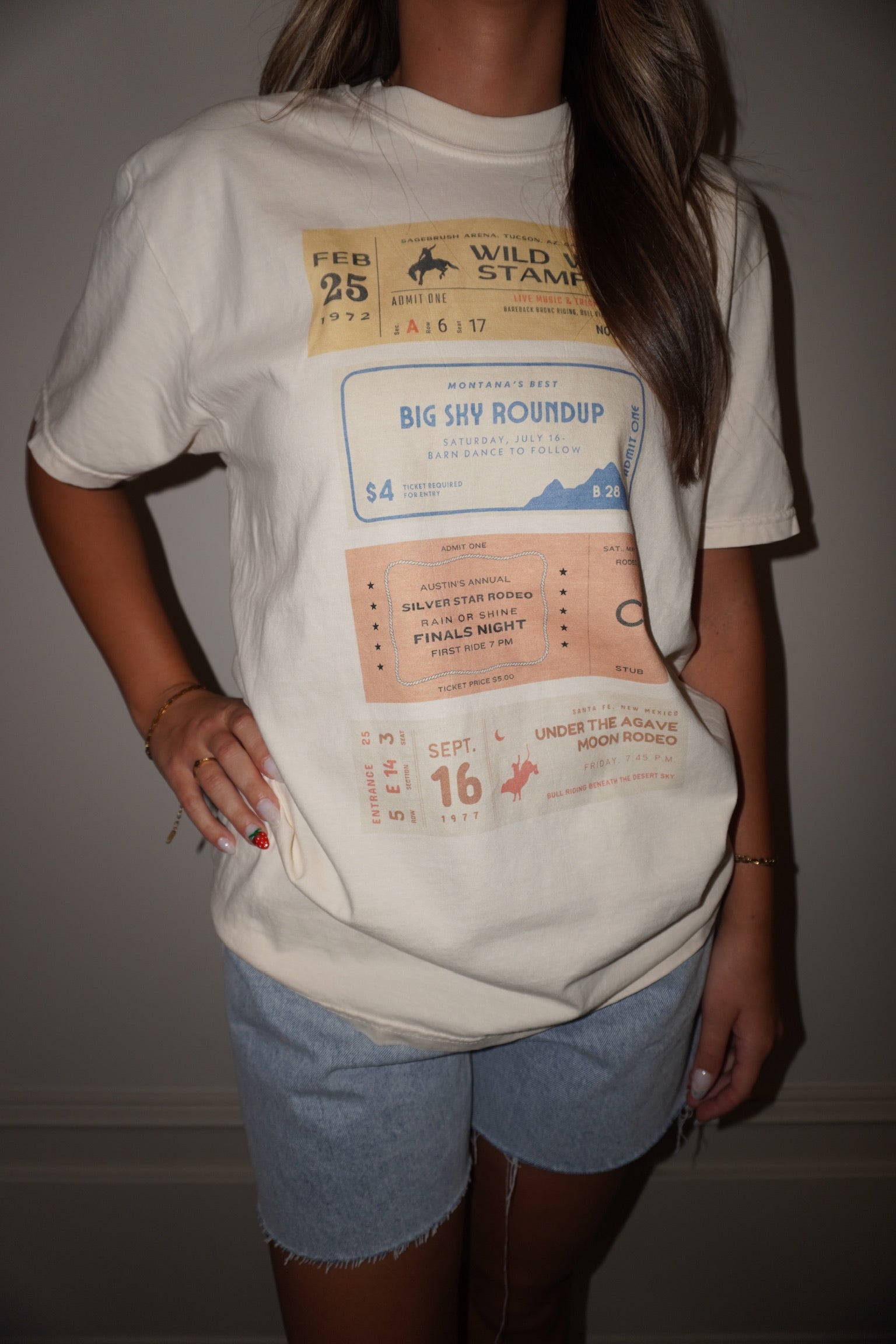 Person wearing a white t-shirt with graphic design, standing against a plain background