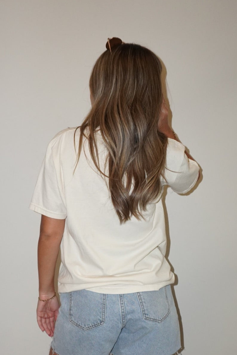 Person wearing a beige shirt and light blue shorts standing on a checkered floor.