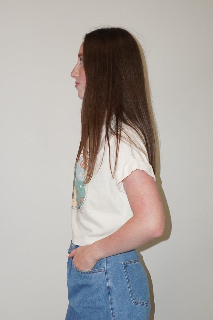 Person wearing a white t-shirt and blue denim shorts standing on a checkered floor.